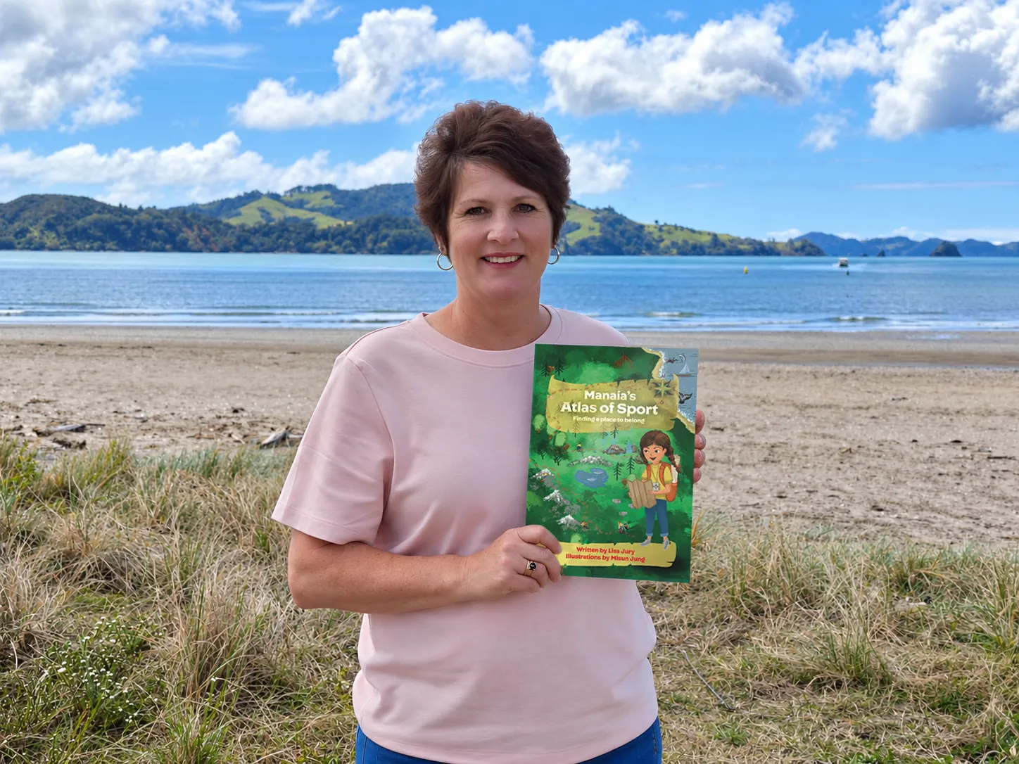 Lisa Jury with Manaia’s Atlas of Sport on a New Zealand beach